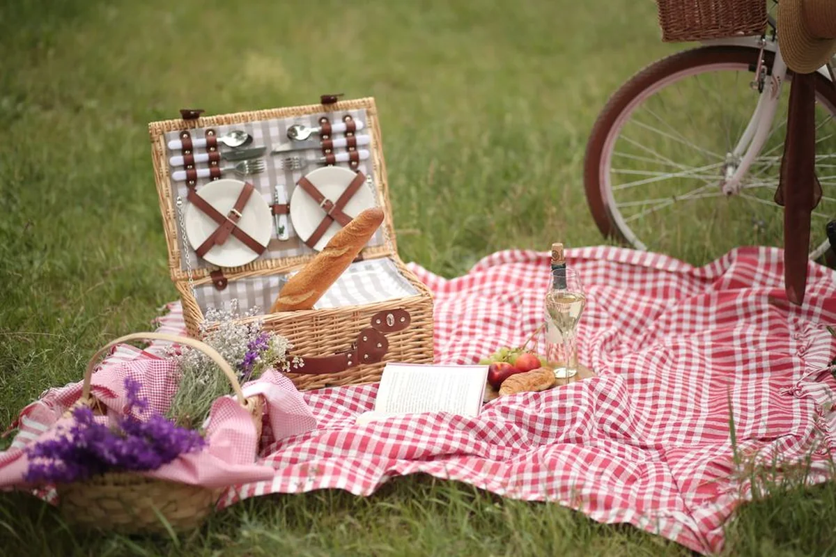 A picnic hamper and food arranged on a blanket