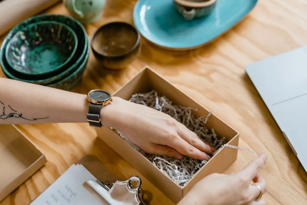 A small gift box being opened on an office desk